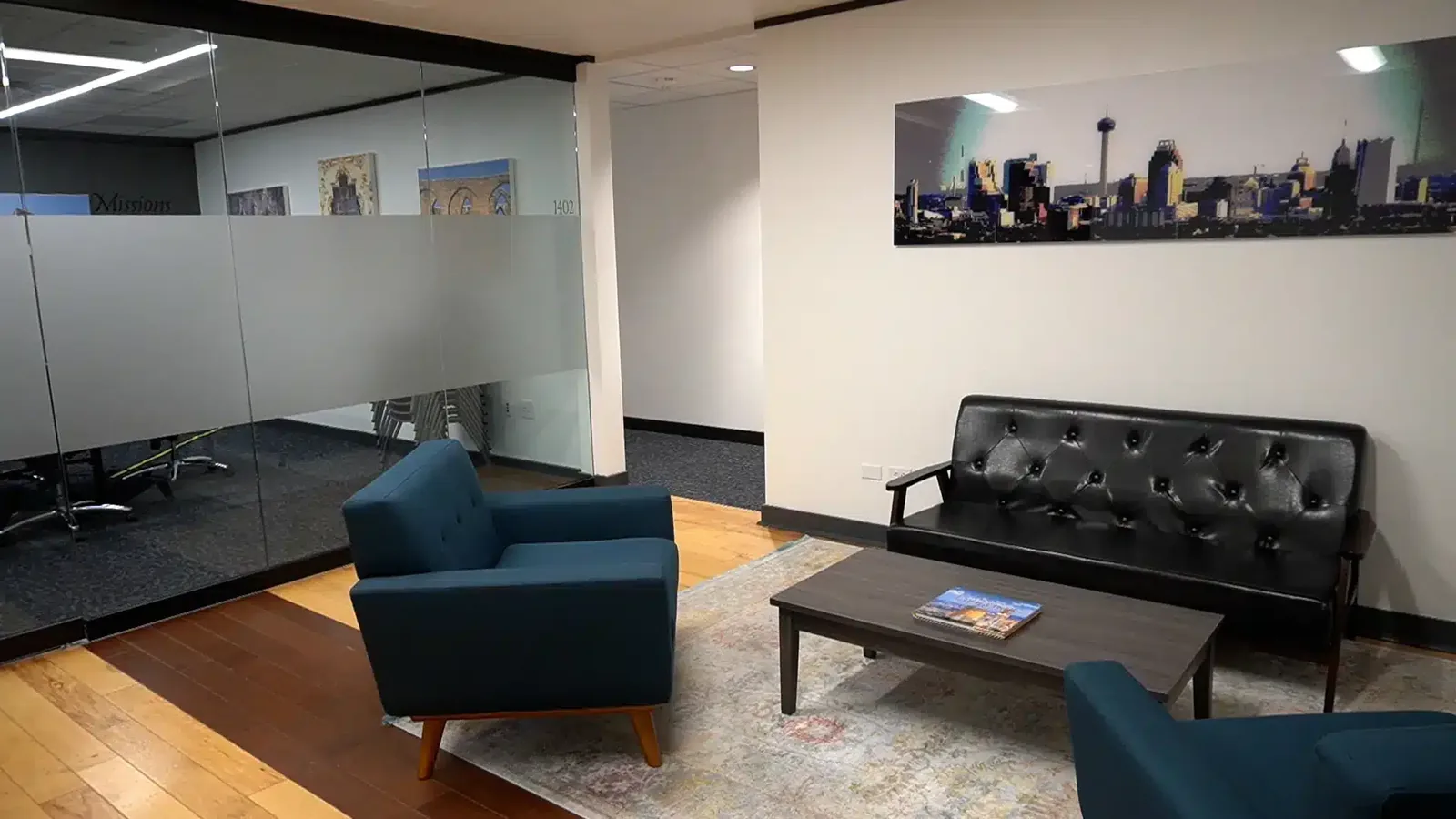 The entrance to a private office suite at SA Cowork in San Antonio, with a glass-walled meeting room alongside