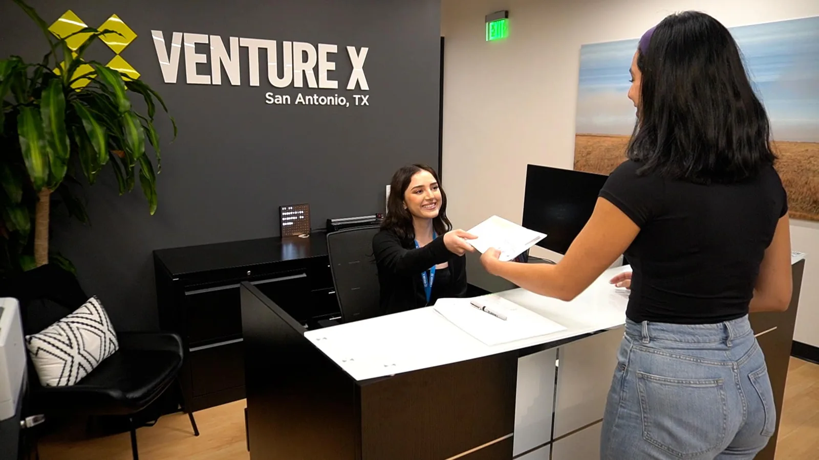 A member collecting mail at the Venture X San Antonio front desk — virtual office mail handling at SA Cowork