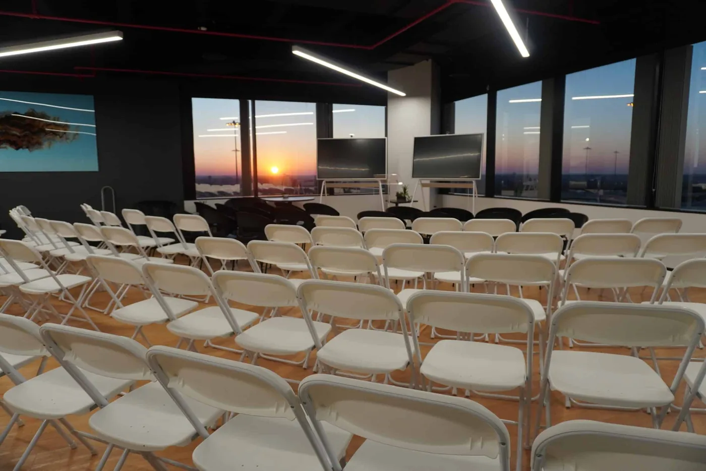 The SA Cowork event space in San Antonio set with rows of seating at sunset, available to rent for workshops, mixers and meetings